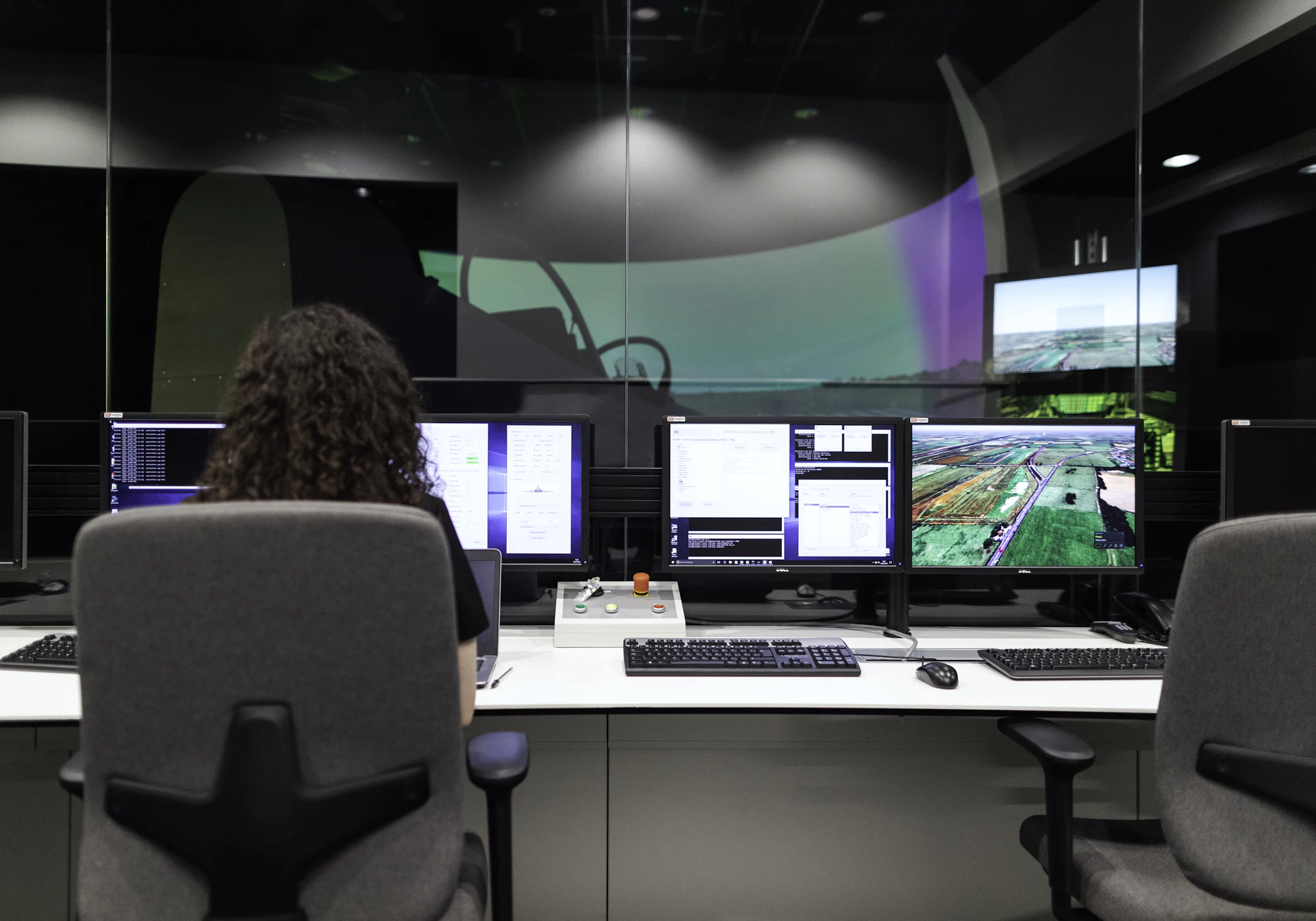 An operations controller at a multi-screen dispatch desk.